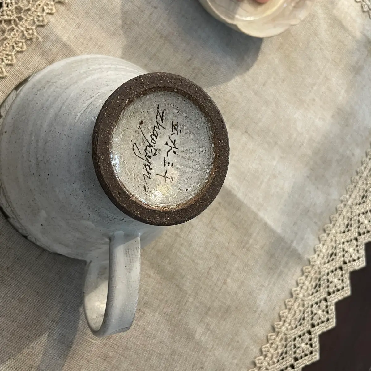 The base of the cup, the pattern name written in Chinese characters with Zhao Ruyan signed beneath, the flat strap handle in view