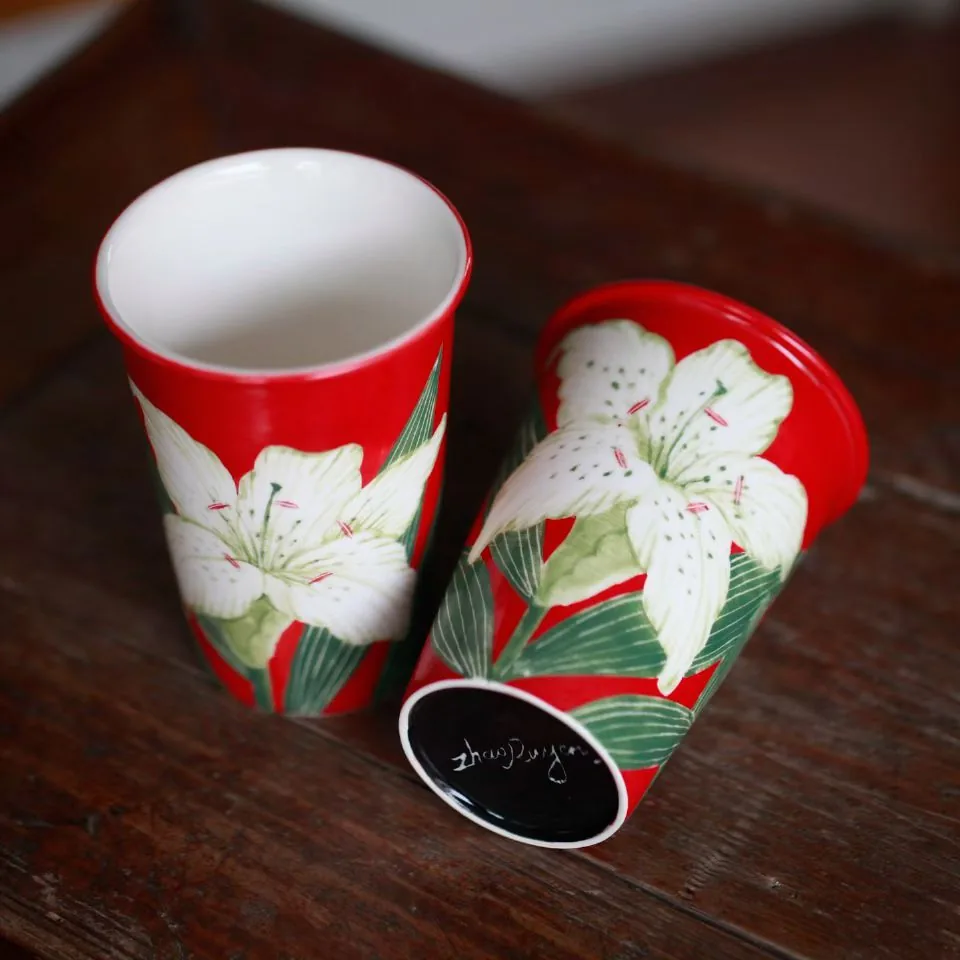 One tumbler upright showing its white interior, the other lying on its side to show the black glazed base signed Zhao Ruyan in white
